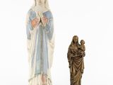 a statue of a woman holding a child next to a statue of a man