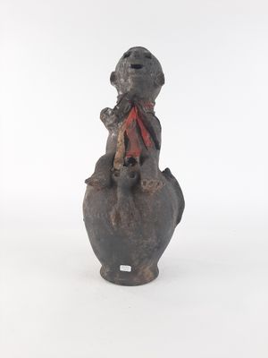 a small statue of a monkey with a red scarf on it ' s neck