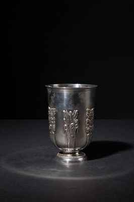 an old silver cup sitting on a table with a black background
