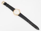 a close up of a watch on a white surface with a black strap