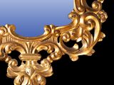 a gold mirror that is on a black background