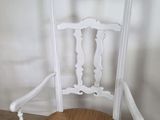 a white chair with a wicker seat on a wooden floor