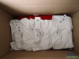 une boîte remplie de t-shirts blancs avec leurs étiquettes encore attachées