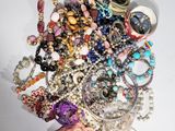 a pile of assorted jewelry on a white surface