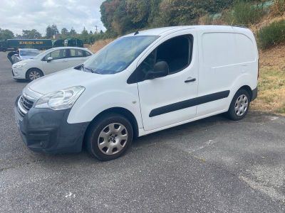 la camionnette blanche est garée dans le parking à côté d'autres voitures