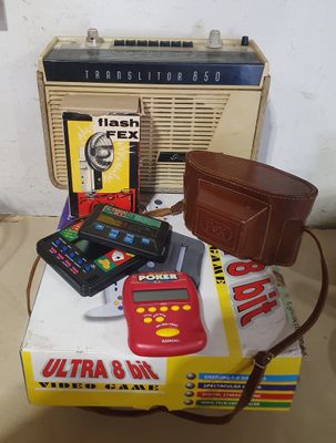 une petite table sur laquelle se trouvent une radio, un portefeuille, un autre portefeuille, un téléphone portable et d'autres objets