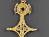 gros plan d'une croix en or sur une surface noire
