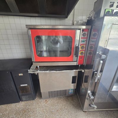 un micro-ondes rouge posé sur un plan de travail dans une cuisine