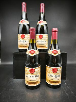 quatre bouteilles de vin sont posées sur une table noire