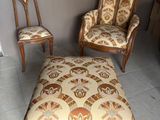 deux fauteuils et un pouf dans une pièce ornée d'un lustre