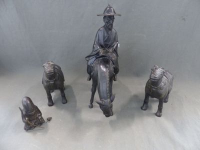 une statue représentant un homme assis sur un cheval, à côté d'autres statues