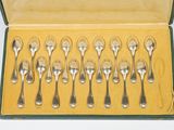 six cuillères dans une boîte posée sur une surface blanche