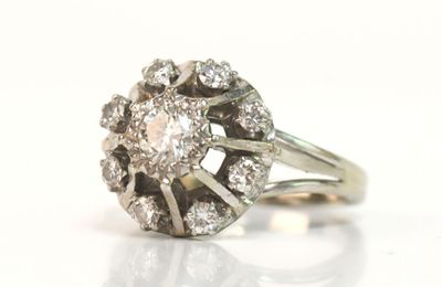 une photo d'une bague en diamant et en or blanc posée sur un fond blanc