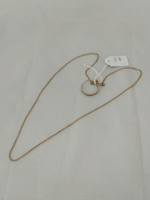 a gold necklace with a white tag on a white background