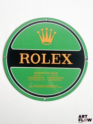 une image représentant l'enseigne Rolex verte et noire sur un mur blanc