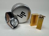 two lighters and a watch sitting next to each other