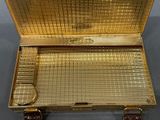 a gold suitcase that is sitting on a table