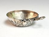 a silver bowl with a spoon in it sitting on a table
