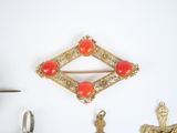 a gold brooch with a red stone in it