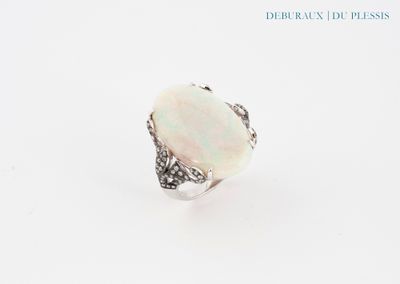 une bague en oplite blanche sertie d'un diamant, sur fond blanc