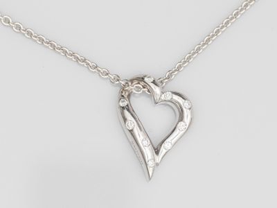 un collier composé d'un cœur en argent serti de diamants, monté sur une chaîne