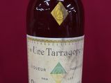 une vieille bouteille de vin posée sur une table rouge