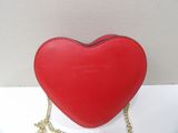 a red heart shaped purse with a gold chain around it
