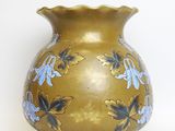 a gold vase with blue flowers on it on a white background