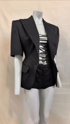 a mannequin dressed mannequin wearing a black jacket and skirt