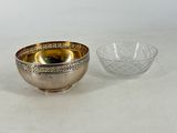 two silver and gold bowls on a white surface