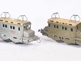 quatre petits trains miniatures posés les uns à côté des autres sur une surface blanche