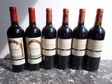 six bouteilles de vin sont alignées sur une table