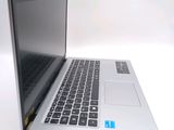 a silver laptop with a black keyboard on a white surface