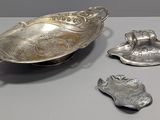 three silver objects are sitting on a table next to each other