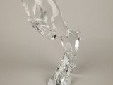 a glass sculpture of a fish on a white surface