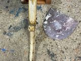 a knife that is laying on the ground next to a rock