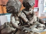 a statue of a boy and a girl reading a book
