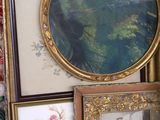 a lot of framed pictures on a shelf in a room