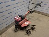 a small lawn mower sitting on the floor in front of a wall