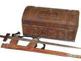 an old wooden chest with two swords and a wooden box