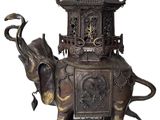 statue en bronze représentant un éléphant et une pagode posés sur un rocher