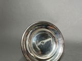 an antique silver plate on a table with a silver background