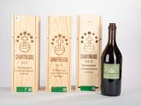 trois caisses à vin en bois et une bouteille de vin posées sur une table