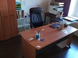a desk with a computer and a chair in a room