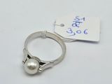 a close up of a ring with a pearl on it