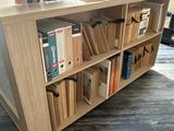 a book shelf with books and a laptop on top of it