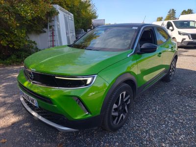 a green suv parked in a parking lot next to a white van
