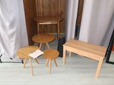 three wooden tables and two stools in a room