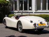 a white sports car parked in front of a house