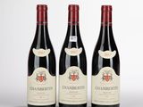 trois bouteilles de vin posées sur une table blanche